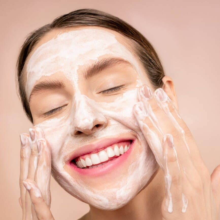 woman with white facial soap on face